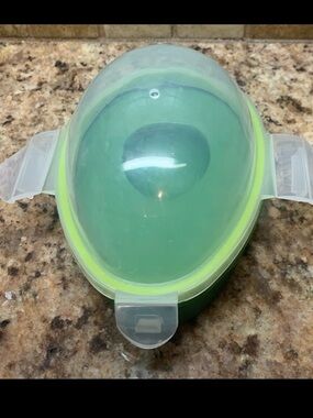 Reusable avocado storage container with clear lid and green base.